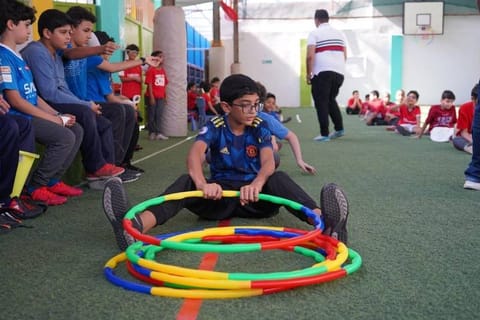 A pupil balancing with hoops in a PE lesson