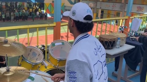 A student playing the drums on stage